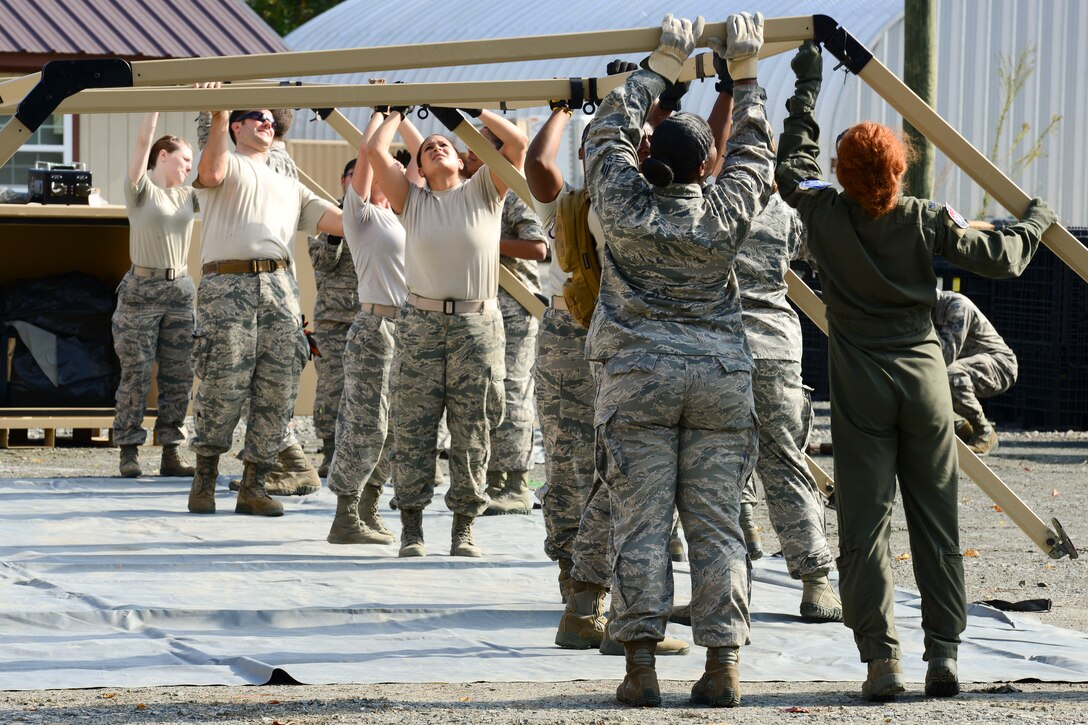 U.S. Air Force Airmen assigned to the 633rd Medical Group set up a tent wall for a medical training exercise at Langley Air Force Base, Va., Oct. 13, 2015. The Airmen must be able to build a hospital with little or no help from civil engineers or logistics readiness in a deployed setting because manpower and resources could be limited. (U.S. Air Force photo by Staff Sgt. Ciara Gosier/Released)