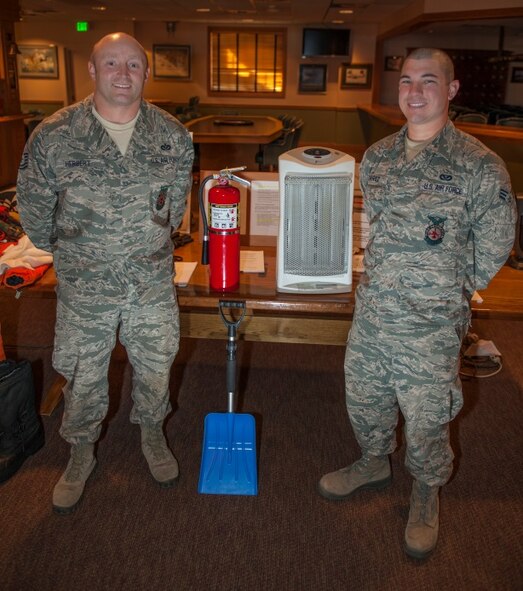 Tech. Sgt. Scott Herbert, 5th Civil Engineer Squadron assistant chief of health and safety, and Senior Airman Nickolas Torrez, 5th CES firefighter, pose with their safety booth at Minot Air Force Base, N.D., Oct. 14, 2015. Minot held a winter safety expo to help educate Minot personnel for the upcoming winter. (U.S. Air Force photo/Airman 1st Class Christian Sullivan)