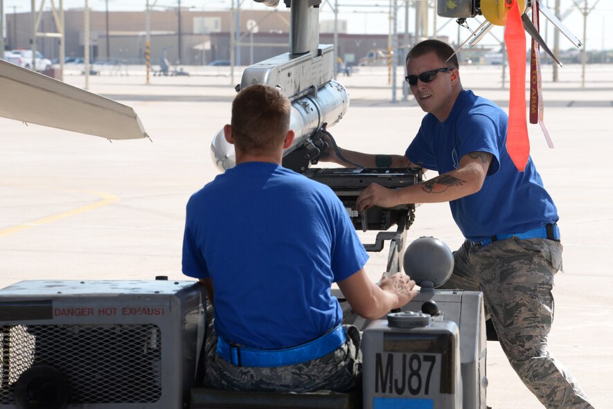 Airman 1st Class Joshua Lomax and O’Brien, 309th AMU load crew members, race to mount a missile on an F-16. The 309th AMU faced off against the 310th AMU and the 425th AMU. (U.S. Air Force photo by Airman 1st Class Ridge Shan)