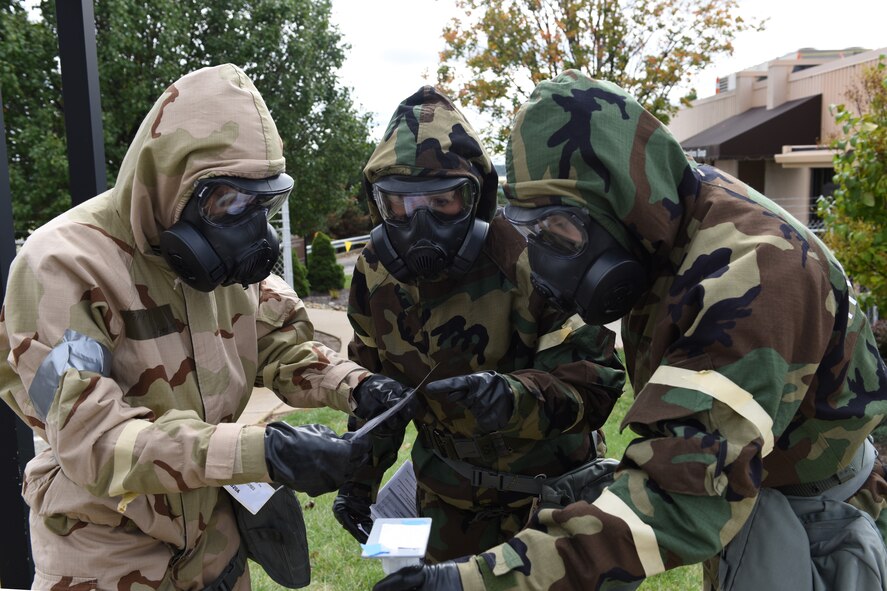 Airmen of the 911th Operations Group examine M8 paper outside of the operations building at the Pittsburgh International Airport Air Reserve Station, Oct. 4, 2015. Airmen dressed in mission oriented protective posture gear during a chemical, biological, radiological, nuclear and explosives exercise that took place here during the unit training assembly. (U.S. Air Force photo by Senior Airman Marjorie A. Bowlden)