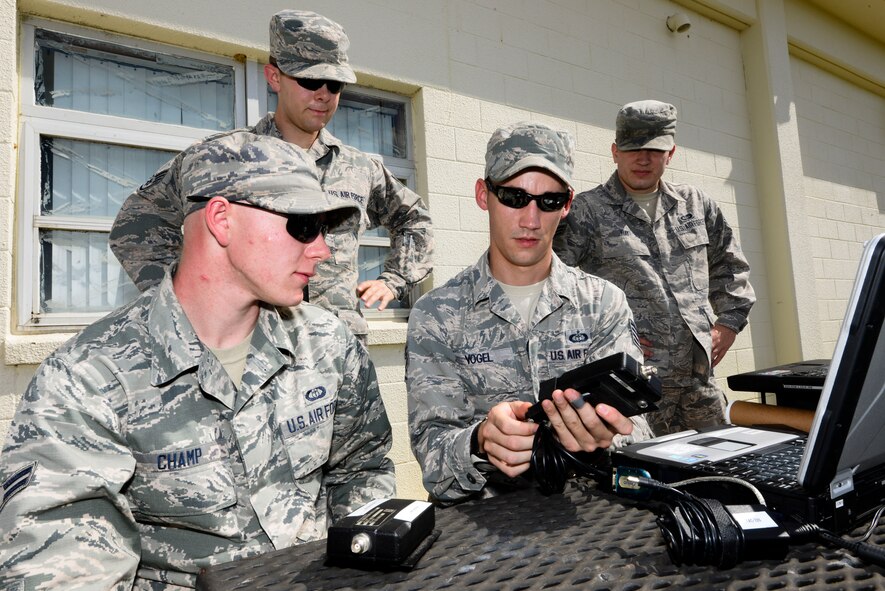U.S. Air Force Staff Sgt. Rudi Vogel (center), 353rd Weather Flight NCO in charge of contingency weather operations and training, demonstrates how to operate a radio modem to Airmen in his flight Oct. 19, 2015, on Kadena Air Base, Japan. The flight conducts hands-on training on a monthly basis to test equipment and sharpen skillsets.  (U.S. Air Force photo by Senior Airman John Linzmeier)