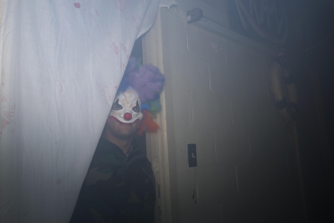 A service member dressed as a clown peers through the smoke in the Futenma Haunted Labyrinth during the VIP opening of the Futenma Haunted Labyrinth Oct. 9 on Marine Corps Air Station Futenma, Okinawa, Japan. The Futenma Haunted Labyrinth is a fundraiser for the Single Marine Program held annually for the past four years. Approximately 200 Okinawa residents and service members navigated the labyrinth and enjoyed a dinner buffet at the Habu Pit. Volunteers in the labyrinth lined hallways and took parts in various scenes throughout the building to provide guests with a fun and frightful experience. The labyrinth is scheduled to open its doors to the public Oct. 23, 24, 29, and 30.