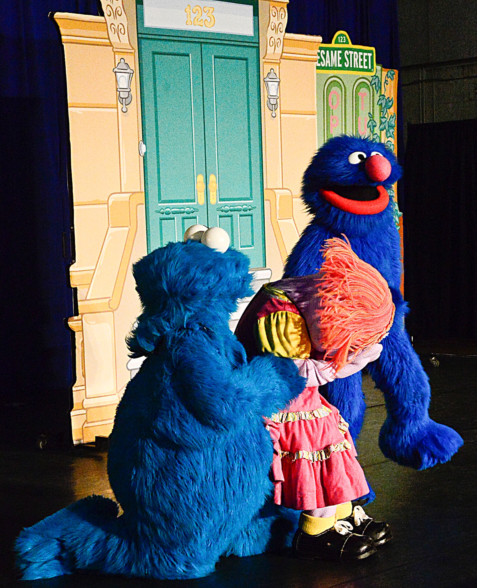 Cookie Monster and Grover console Katie (center) during the United Service Organization Sesame Street performance on Osan Air Base, Republic of Korea, Oct. 15, 2015. The USO teamed with Sesame Street to help military children understand different challenges they may face. Katie learned that sometimes change is good, like moving to a new base. (U.S. Air Force photo/Senior Airman Kristin High)