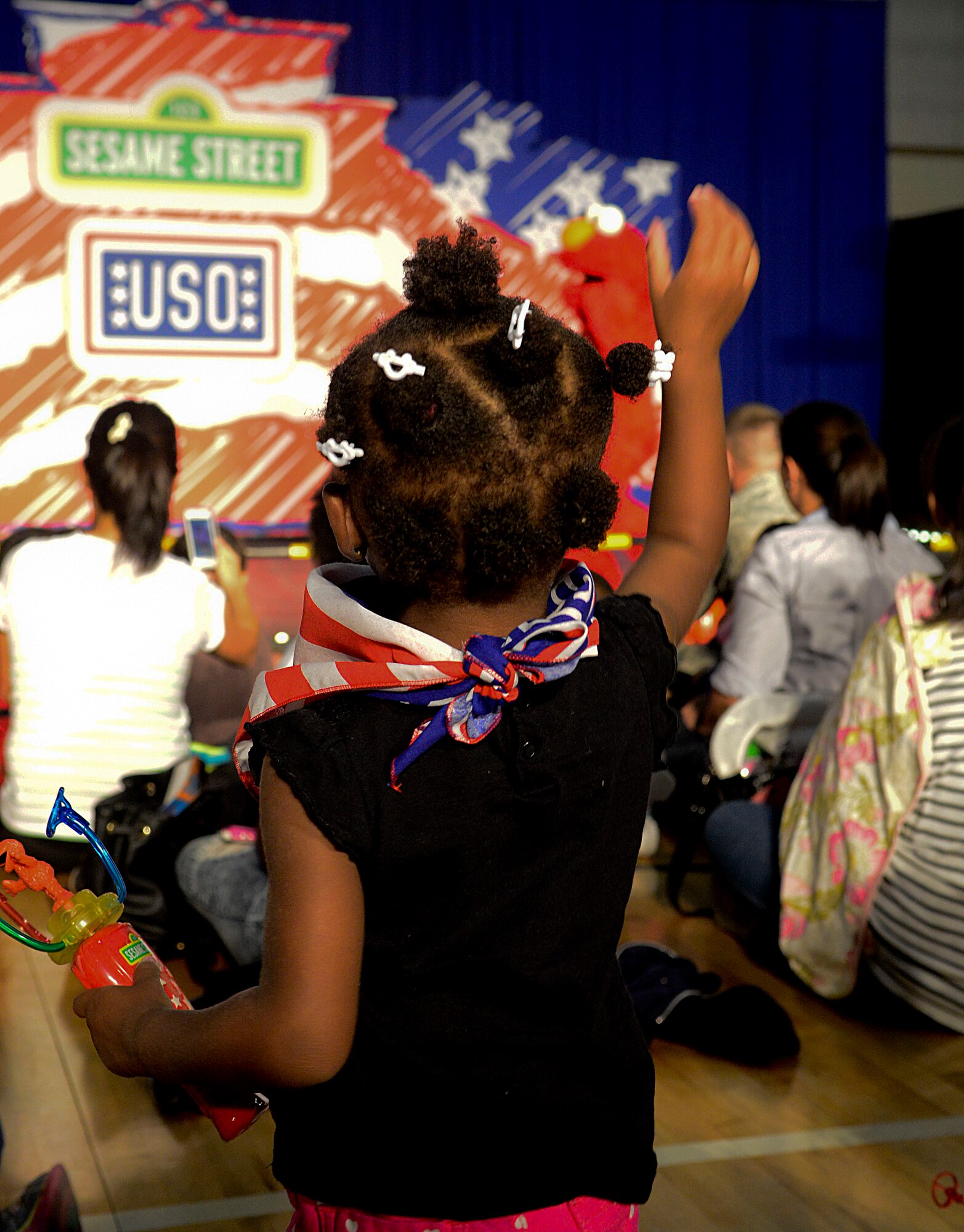 A child waves at Elmo during the United Service Organization Sesame Street presentation on Osan Air Base, Republic of Korea, Oct. 15, 2015. During the presentation children learned tips on moving to a new base, like how to keep in touch with old friends and make new ones. (U.S. Air Force photo/Senior Airman Kristin High)