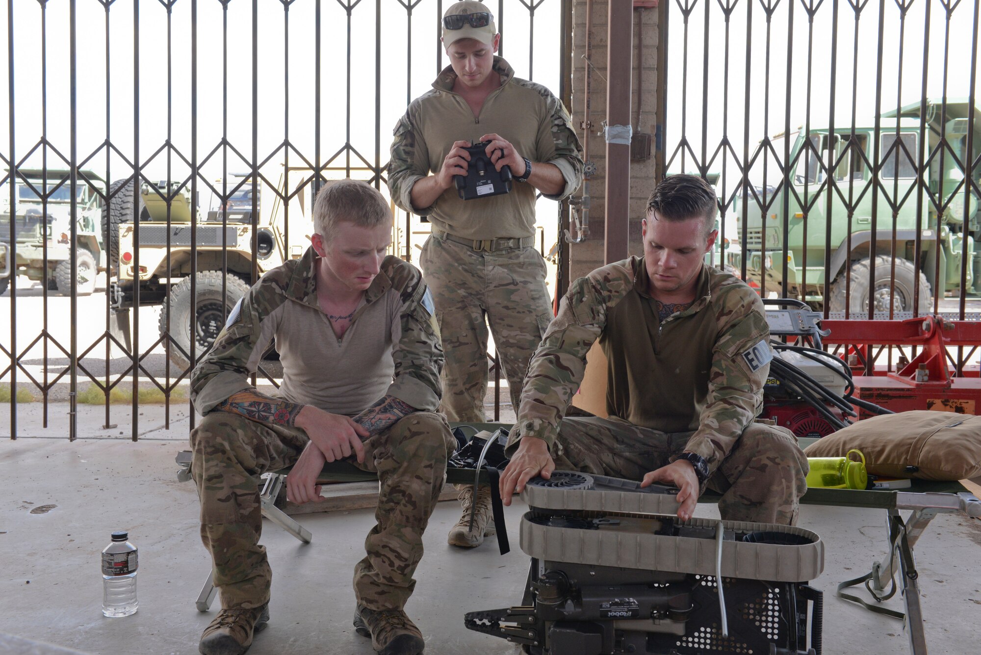 Staff Sgt. Michael Garrison, , 56th CES EOD team leader, demonstrates aspects of a remote controlled robot to Senior Airman Matthew Ezell, 355th CES EOD team member, and Staff Sgt. Sheldon Shockley, 355th CES EOD team leader at Gila Bend, Sept. 3, 2015. EOD technicians use robots to deal with explosives whenever possible to minimize risk to human life. (U.S. Air Force photo by Airman 1st Class Ridge Shan)