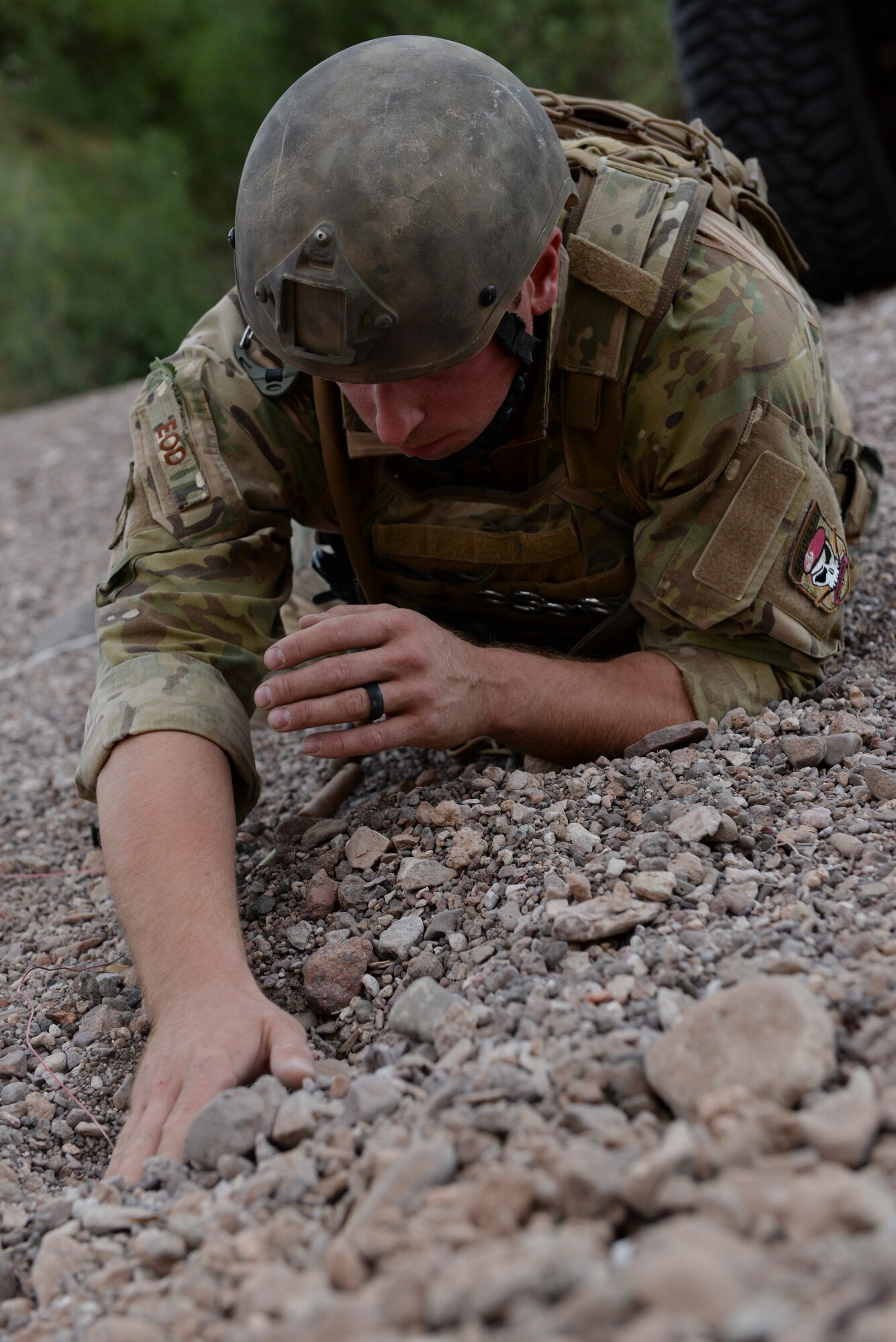 Staff Sgt. Sheldon Shockley, 56th Civil Engineer Squadron Explosive Ordnance Disposal team leader, feels for an improvised explosive device buried beneath pebbles during Operation Enduring Training Sept. 3 at the Barry M. Goldwater Range. (U.S. Air Force photo by Airman 1st Class Ridge Shan)