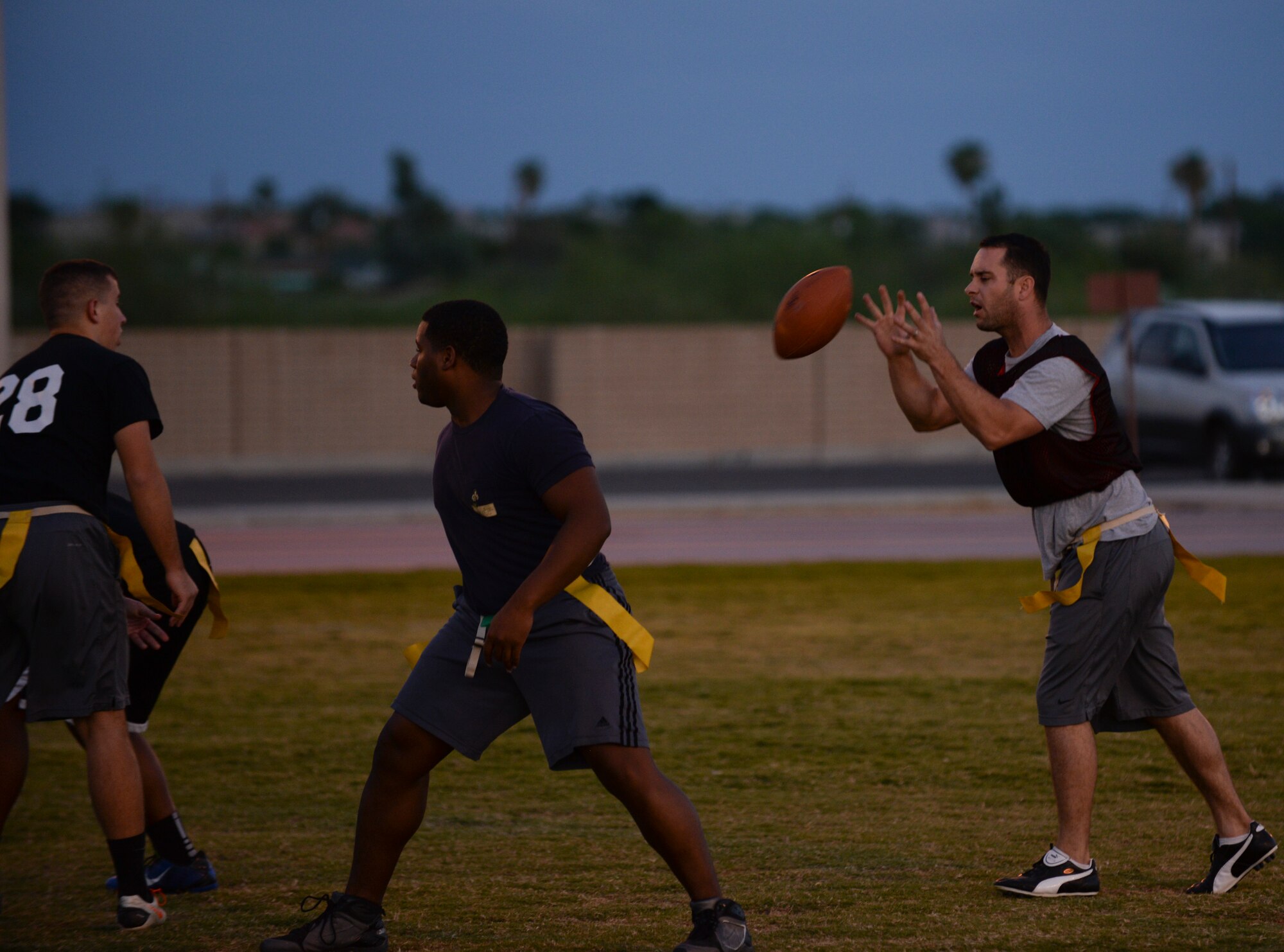 Senior Airman James Smith, quarterback for the 56th Operations Support Squadron flag football team, receives a hike Oct. 5 at Luke Air Force Base. Flag football between Luke unit teams occurs weekly and inspires intense competition. (U.S. Air Force photo by Airman 1st Class Ridge Shan)