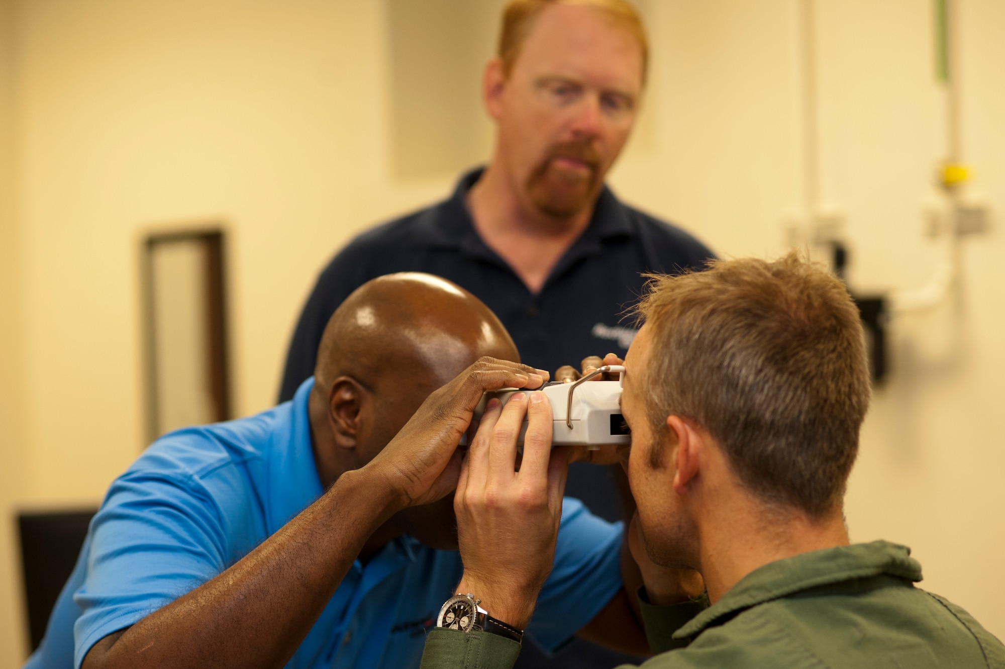Christopher Culley, Rockwell Collins customer support specialist, performs measurements for an F-35 Lightning ll Generation lll helmet mounted display system at the pilot fit facility at  Luke Air Force Base. Measurements are taken of the pilot’s head, including a 3-D head scan and the use of a pupilometer to measure the distance between the pupils. (U.S. Air Force photo by Staff Sgt. Staci Miller