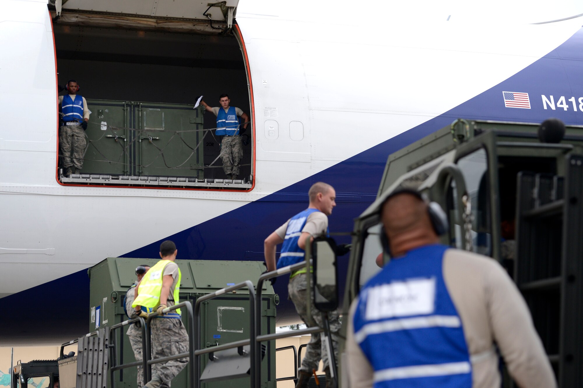 U.S. Air Force Airmen assigned to the 20th Logistics Readiness Squadron, wait for cargo to reach the end of a 60K-Loader at Shaw Air Force Base, S.C., Oct. 1, 2015. The 20th LRS spent several days loading 285 tons of cargo onto various aircraft. (U.S. Air Force photo by Senior Airman Jensen Stidham/Released)