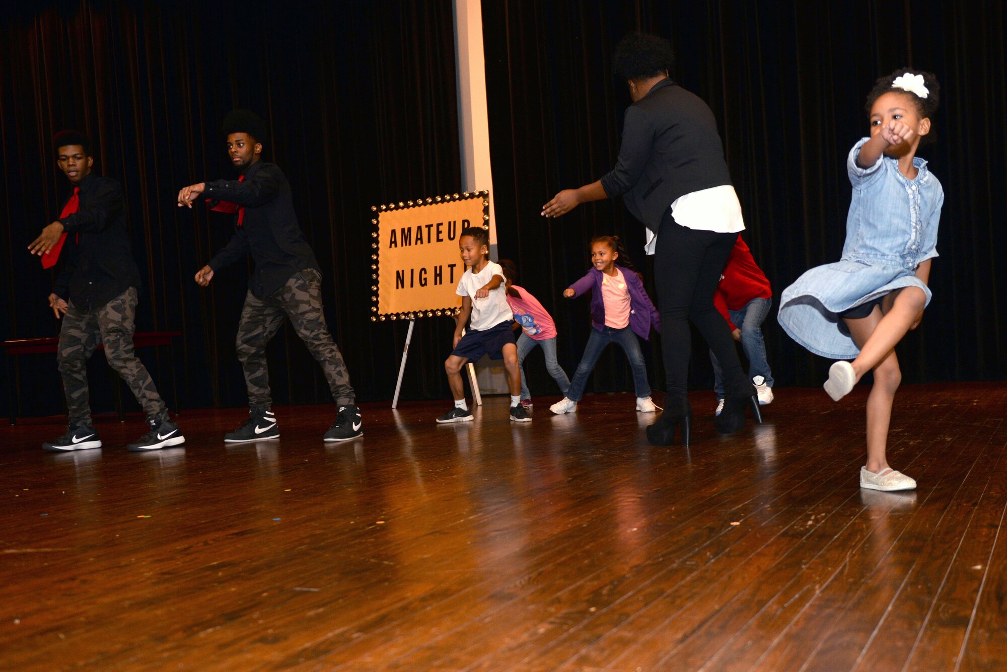 Members of Team Seymour dance on stage during the base talent show intermission, Oct. 16, 2015, at Seymour Johnson Air Force Base, North Carolina. During the intermission, performers and members of the audience danced while the second round of performers prepared themselves to go on stage. (U.S. Air Force photo/Airman 1st Class Ashley Williamson)