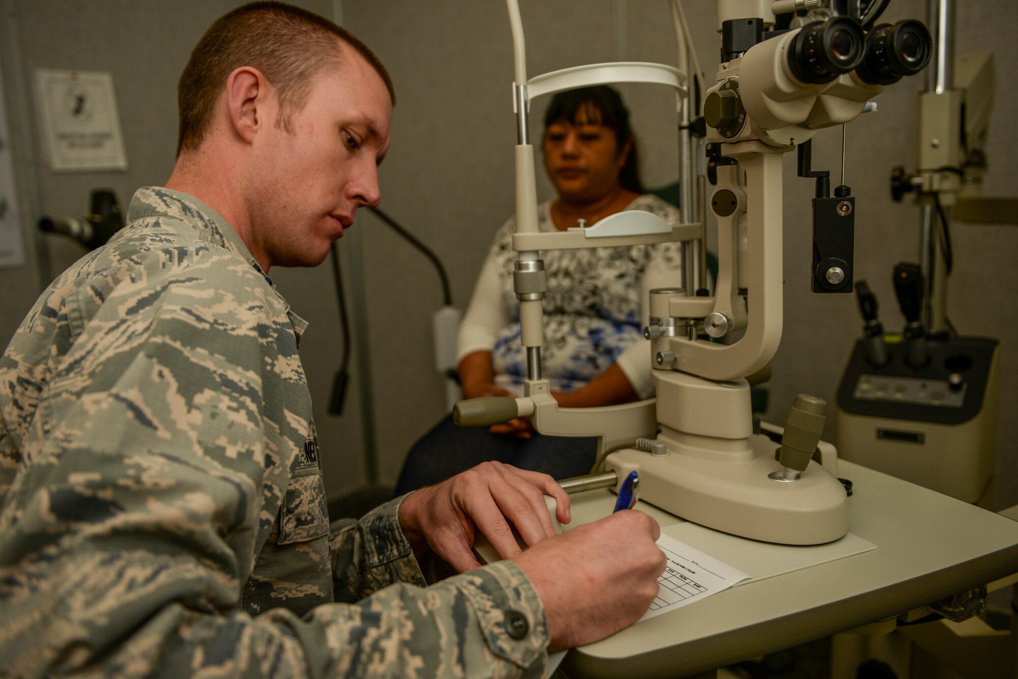 Capt. Jerom Nelson, an optometrist with the 49th Medical Group, writes a prescription for his patient, Patricia Bellard, at Holloman Air Force Base, N.M., Oct. 19. Optometrists here provide services to military members and their dependents. “We see a full scope of military members and their families,” Nelson said. “Our main priority is the mission and keeping Airmen ready for deployments.” (U.S. Air Force photo by Airman 1st Class Randahl J Jenson/ Released)