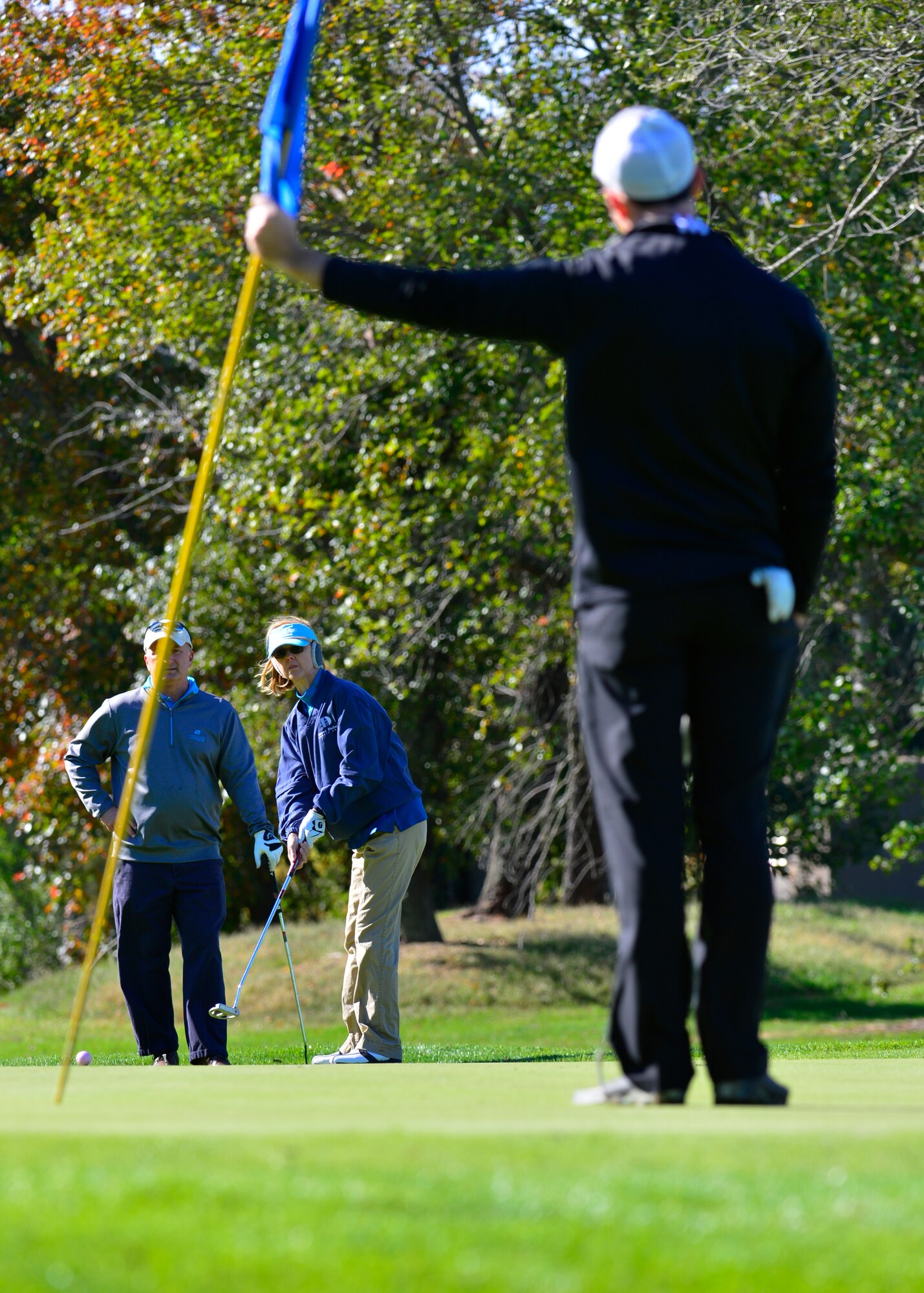 Maj. Paul Schimpf, 436th Operations Support Squadron assistant director of operations, pulls the pin while Bettie Campbell, honorary commander alumnus, putts a golf ball during the 2015 fall Bluesuiters Golf Tournament Oct. 16, 2015, at Eagle Creek Golf Course on Dover Air Force Base, Del. Bluesuiters is a semi-annual golf tournament that connects Team Dover Airmen with local civic and business leaders. (U.S. Air Force photo/Senior Airman William Johnson)
