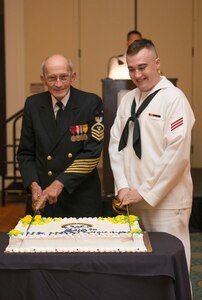 Sam Kirton, Navy retired Master Chief Petty Officer, cuts the Navy’s birthday cake with Fireman Nicholas Scorsome, Naval Power Training Unit student, at the Navy Ball for the Navy’s 240th birthday at the Charleston Marriott Hotel on Oct. 17, 2015. To cut the cake, the speaker chose the oldest and youngest Navy members attending the Navy Ball.