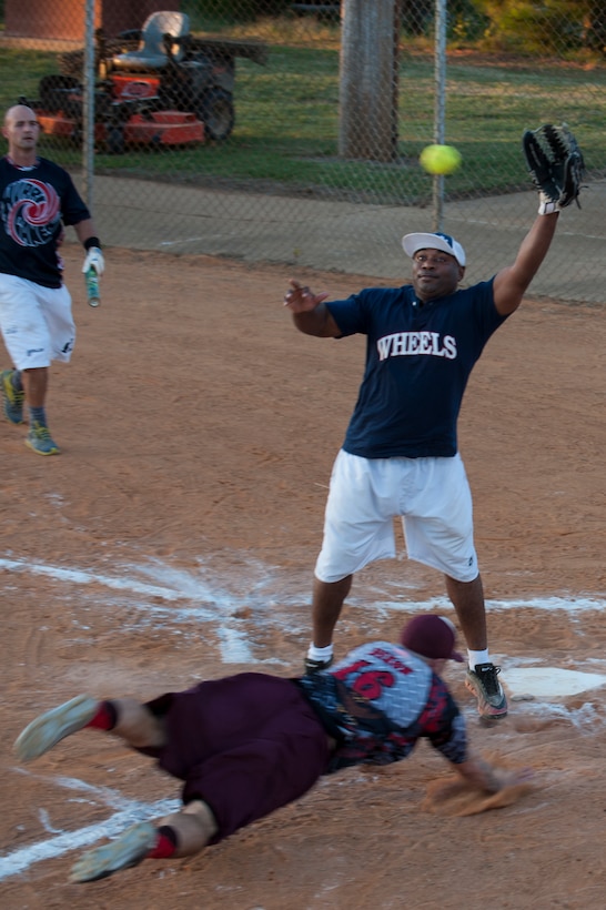 Deametrious Bagwell, Fort Eustis All-Stars catcher, jumps for the ball while Garrett Dixon, Langley All-Stars outfielder, dives for home plate during the Joint Base Langley-Eustis All-Stars Softball game at Langley Air Force Base, Va., Oct. 14, 2015. The All-Stars game was held as part of the on-going Commander’s cup competition and gathered the best players from the 2015 JBLE intermural softball season. (U.S. Air Force photo by Senior Airman R. Alex Durbin/Released)