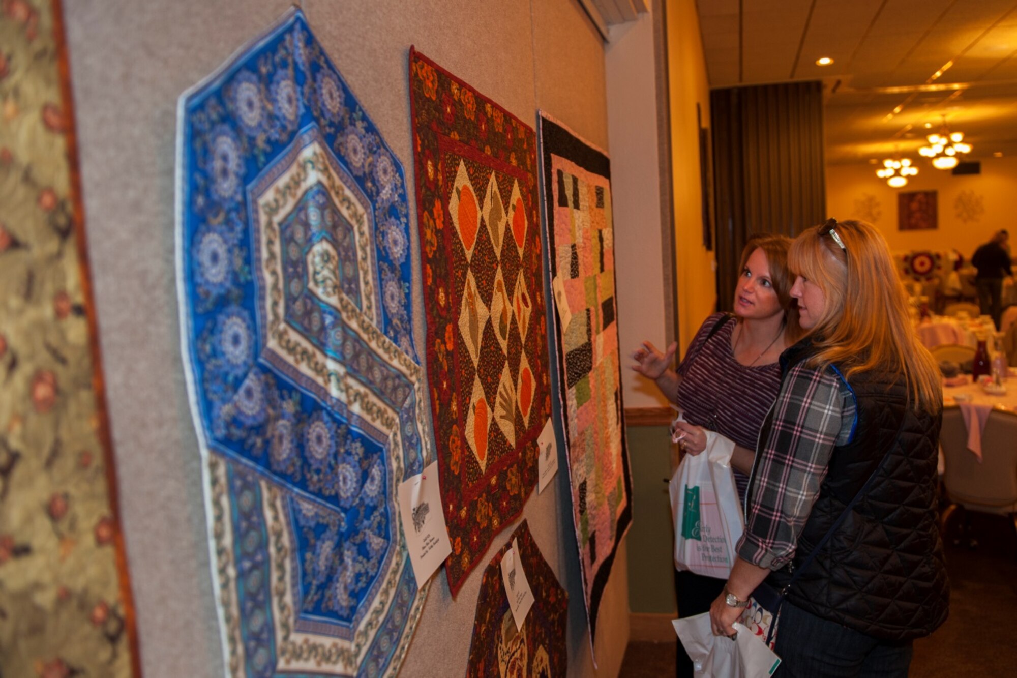 Members of Team Minot look at quilts during the breast cancer awareness luncheon at Minot Air Force Base, N.D. Oct. 9, 2015. The luncheon featured silent auctions and raffles in support of breast cancer research funding. (U.S. Air Force photo/Airman 1st Class Christian Sullivan)