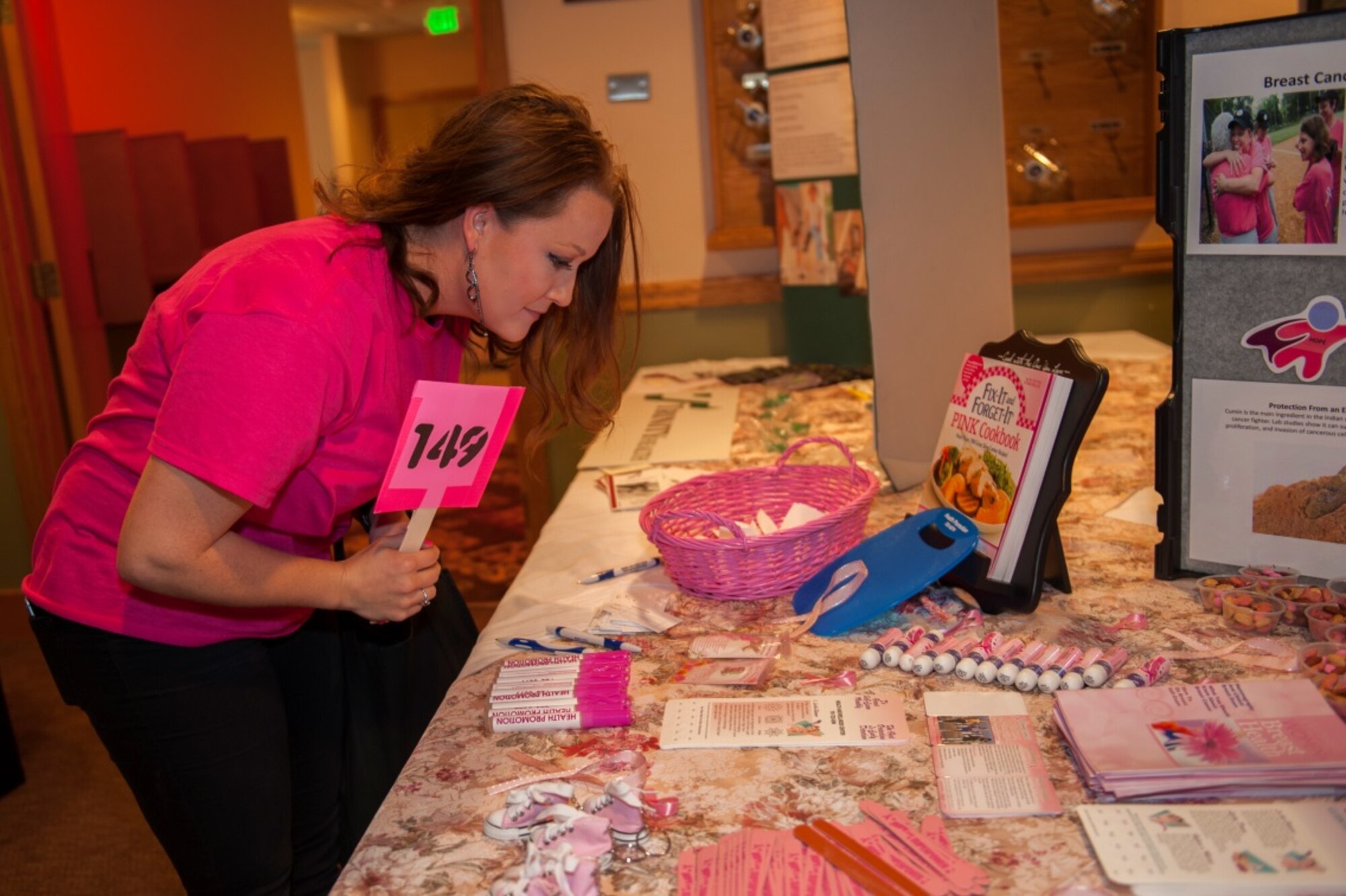 Staff Sgt. Bridget Bollinger, 5th Force Support Squadron missile chef, looks at raffle tickets during the annual breast cancer awareness luncheon at Minot Air Force Base, N.D., Oct. 9, 2015. The luncheon gave away various pink and breast cancer related items in support of breast cancer research funding. (U.S. Air Force photo/Airman 1st Class Christian Sullivan)