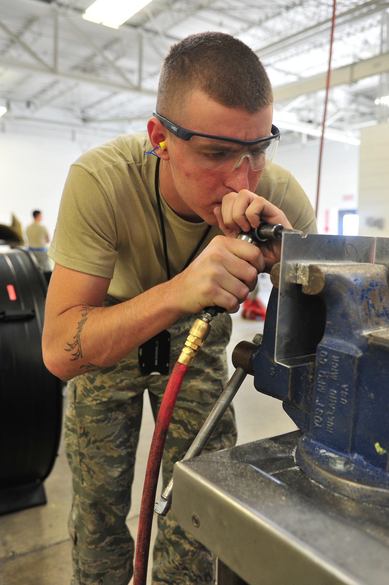 Senior Airman Johnathan Hilliker, 5th Maintenance Squadron aircraft structural maintenance journeyman, grinds the edge of a piece of metal at Minot Air Force Base, N.D., Oct. 14, 2015. Hilliker shaped the piece to fit on a classified materials safe box which is stored in the aircraft. (U.S. Air Force photo/Senior Airman Stephanie Morris)