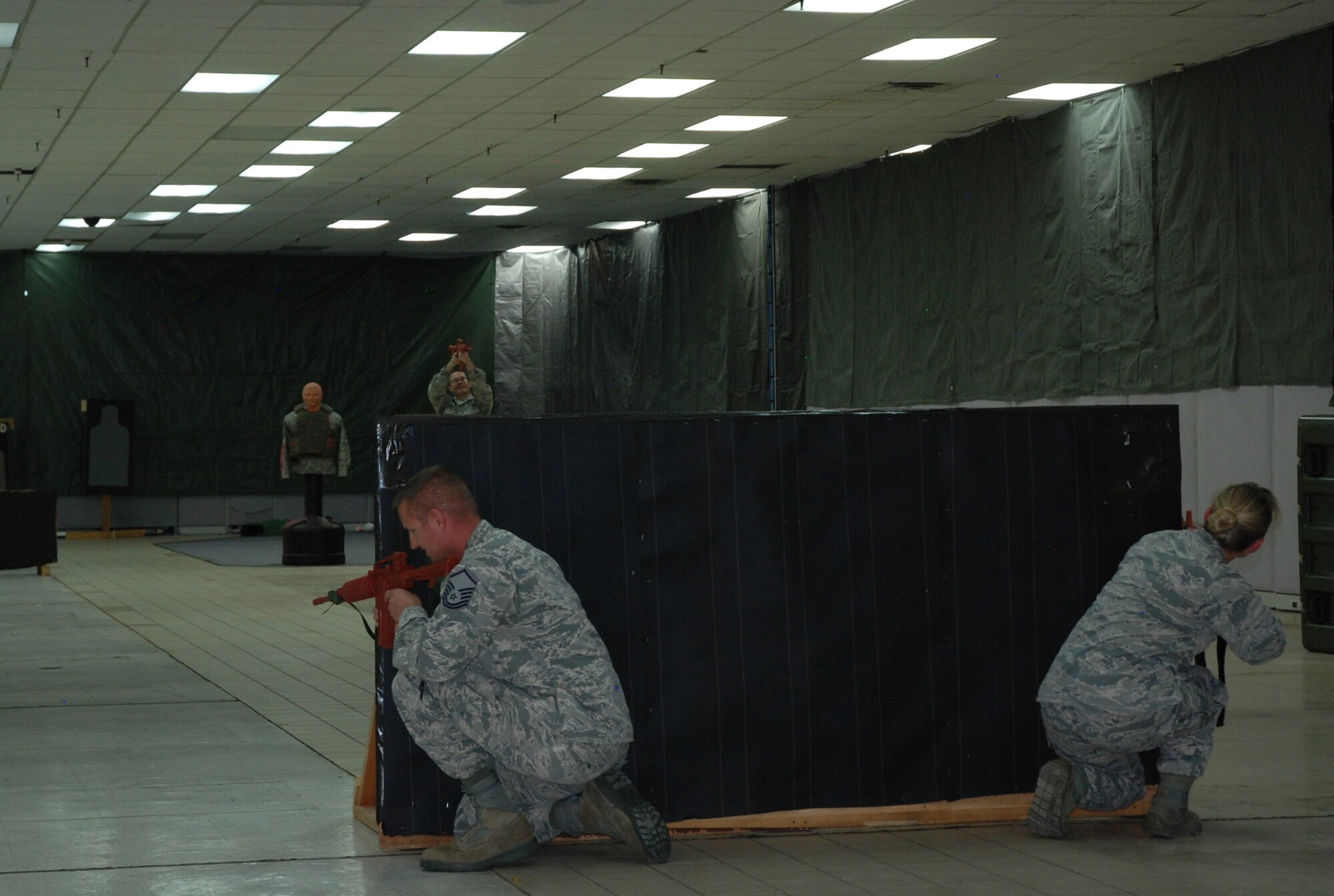 PETERSON AIR FORCE BASE, Colo. -- Airmen practice approaching an active shooter as a team during Expeditionary Active Shooter Training, a new tier-two level training for all deploying Airmen, Oct. 14, 2015. The new classes, which began this month, are held weekly to accommodate deployment schedules. (U.S. Air Force photo by Dave Smith)
