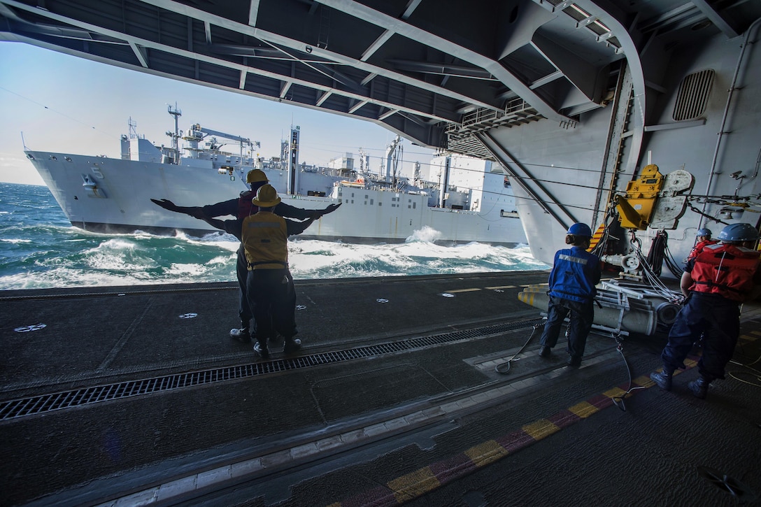 U.S. sailors practice hand signals aboard the aircraft carrier USS Dwight D. Eisenhower during an ammunition transfer from cargo and ammunition ship USNS Robert E. Peary, in the Atlantic Ocean, Oct. 13, 2015. U.S. Navy photo by Petty Officer 3rd Class J. E. Veal

