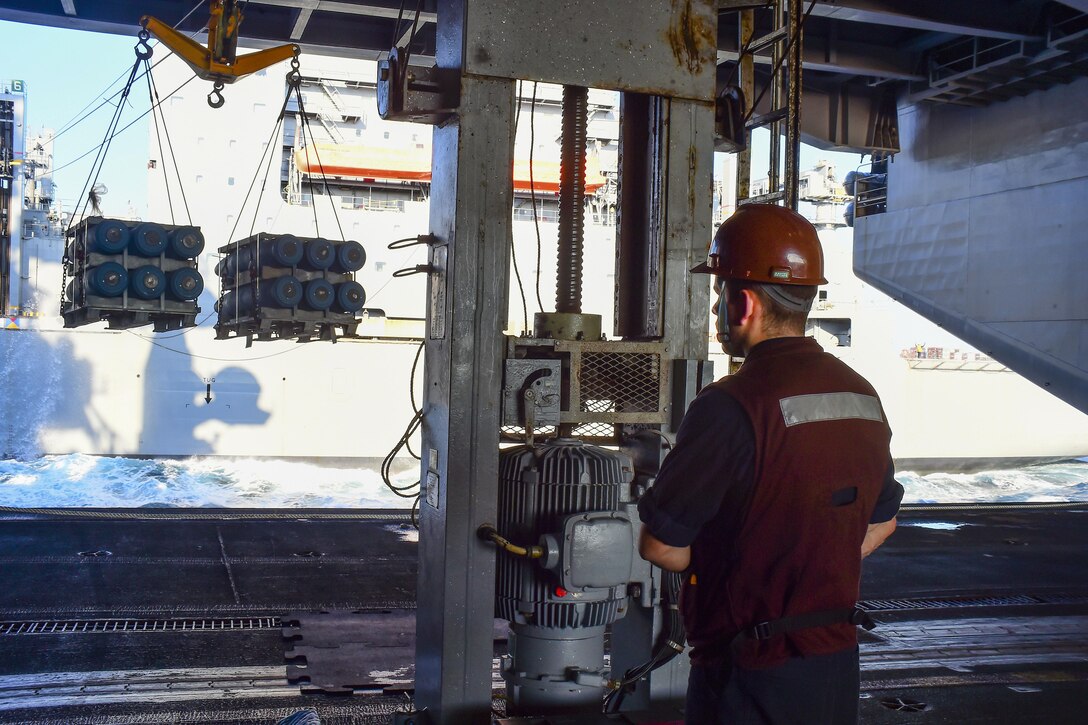 U.S. Navy Seaman Max Schoonover controls cargo from the aircraft carrier USS Dwight D. Eisenhower during an ammunition replenishment  in the Atlantic Ocean, Oct. 13, 2015. The supplies were transferred from the dry cargo and ammunition ship USNS Robert E. Peary. U.S. Navy photo by Seaman Anderson W. Branch