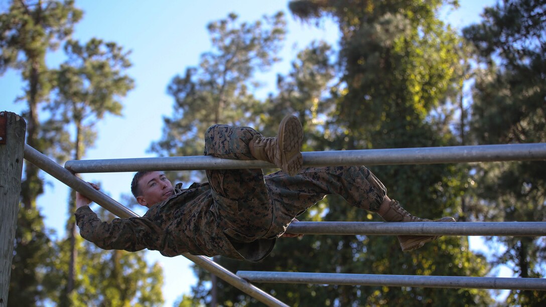 A Marine candidate with the Scout Sniper Screening Platoon, 2nd Battalion, 8th Marine Regiment, maneuvers over an obstacle as part of the Scout Sniper Physical Assessment Test at Camp Lejeune, N.C., Oct. 19, 2015. The obstacle course served as the final evolution for the assessment, requiring two consecutive completions from each candidate. 