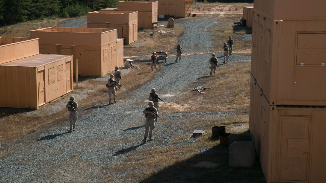 Marines from Alpha Company, Marine Barracks Washington, D.C. patrol an area with a suspected sniper during a military operations in urban terrain exercise at Marine Corps Base Quantico, Virginia. Oct. 15, 2015.