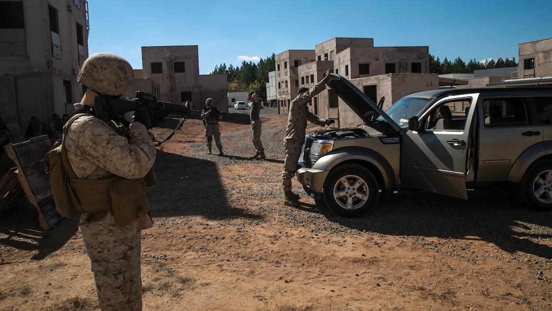 Marines from Alpha Company, Marine Barracks Washington, D.C. search a vehicle at a vehicle control point as part of a military operations in urban terrain exercise at Marine Corps Base Quantico, Virginia, Oct. 15, 2015.