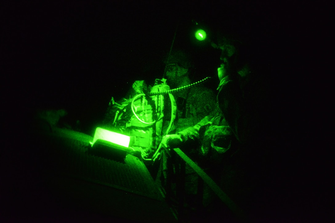 As seen through a night-vision device, A U.S. paratrooper conducts a radio check during a night live-fire exercise as part of Exercise Rock Proof V at Pocek Range in Postonja, Slovenia, Oct.18, 2015. U.S. Army photo by Davide Dalla Massara