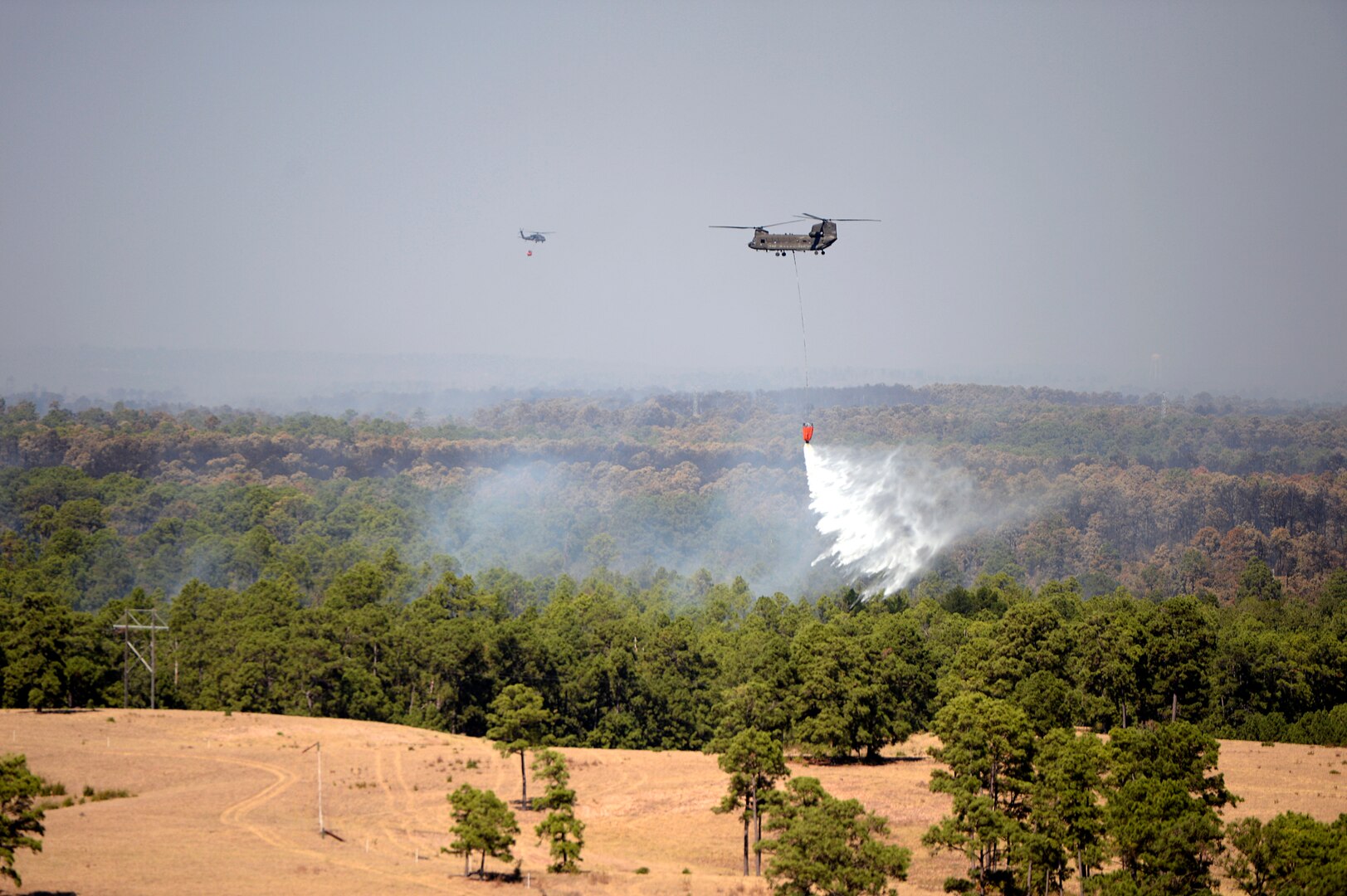 A Texas Army National Guard CH-47 Chinook from Grand Prairie and a UH-60 Black Hawk from the Austin Army Aviation Facility assist in suppressing a wildfire in Bastrop County, Texas. 