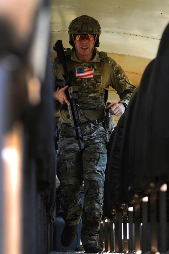 A Green Beret soldier runs down the aisle of a derelict school bus used as a training aid during a stress shoot competition on Eglin Air Force Base, Fla., Oct. 15, 2015. He is assigned to the 7th Special Forces Group. The competition tests the Special Forces soldier's ability to navigate terrain and obstacles while engaging targets accurately despite an elevated heart rate and rapid breathing. U.S. Army photo by Staff Sgt. William Waller