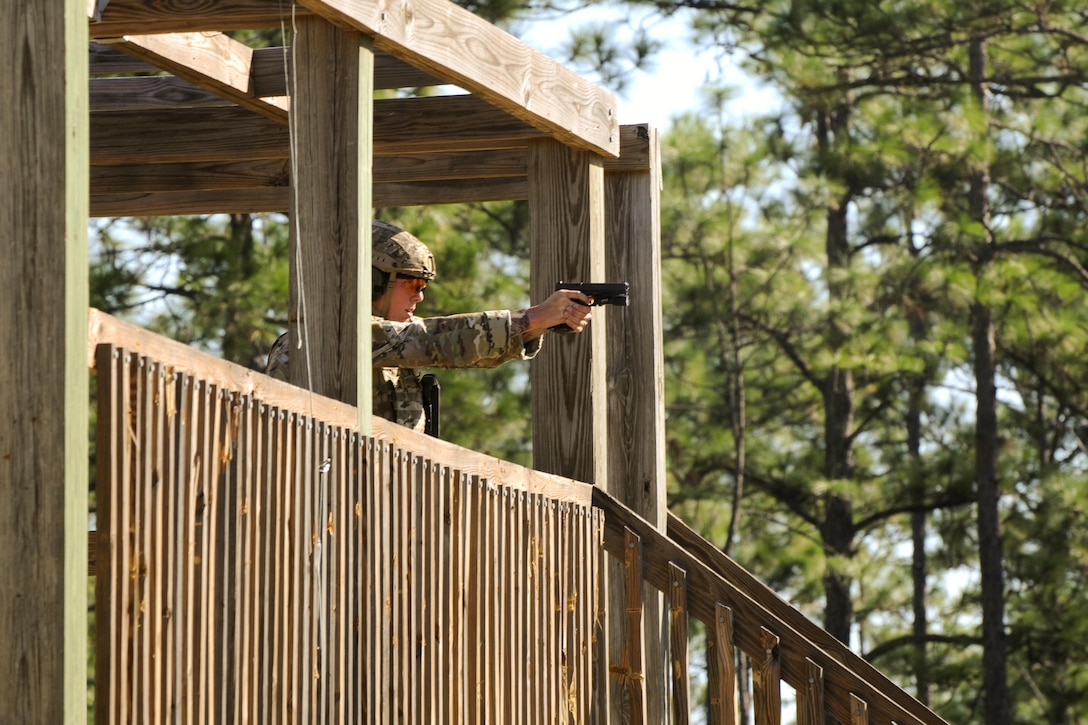 A Green Beret soldier shoots targets with a handgun from an elevated firing position during a stress shoot competition on Eglin Air Force Base, Fla., Oct. 15, 2015. He is assigned to the 7th Special Forces Group. The competition tests the Special Forces soldier's ability to navigate terrain and obstacles while engaging targets accurately despite an elevated heart rate and rapid breathing. U.S. Army photo by Staff Sgt. William Waller