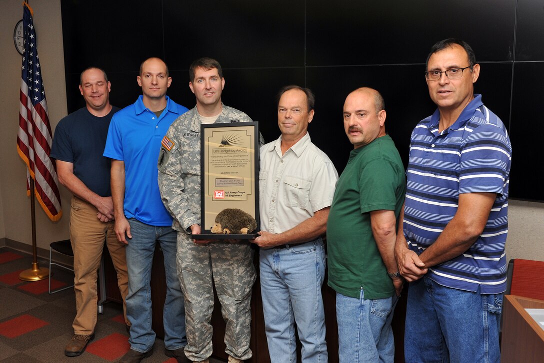 Lt. Col. Stephen Murphy, U.S. Army Corps of Engineers Nashville District commander, presents the Hedgehog Award to members of a spillway gate bulkhead repair team at the district headquarters in Nashville, Tenn., Oct. 15, 2015. The award is given quarterly by the Nashville District to individuals or team of employees to recognize excellence. Cheatham Dam is located in Ashland City, Tenn. From Left to Right are Terry Hudgins, Josh Marcum, Murphy, Larry Myers, Chris Sherek and Ramiro Santoyo.