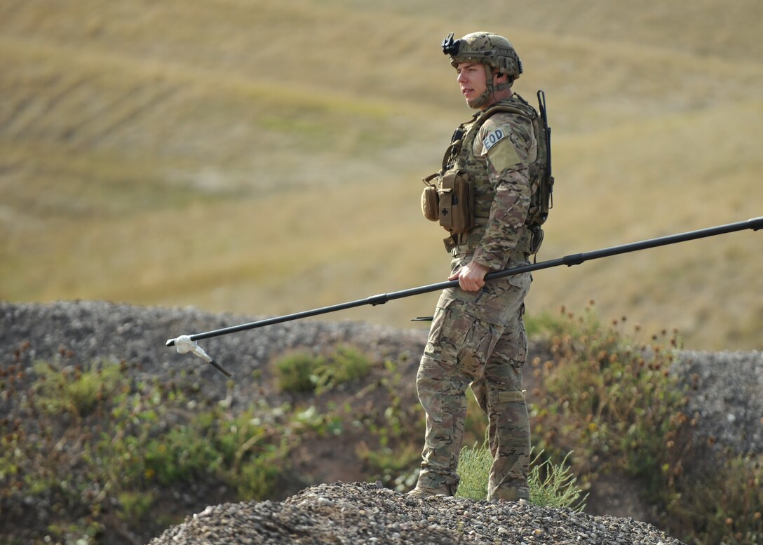 Staff Sgt. Scott Greco, 28th Civil Engineer Squadron explosive ordnance disposal craftsman, use a bang stick to clear a path for an EOD bomb team at Ellsworth Air Force Base, S.D., Oct. 6, 2015. The bang stick is a collapsible painter’s pole made out of carbon fiber or plastic and is used to investigate explosive devices while maintaining a safe distance. (U.S. Air Force photo by Airman Sadie Colbert/Released) 