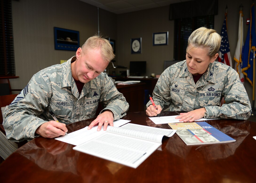 U.S. Air Force Chief Master Sgt. Mark Hurst, 633rd Air Base Wing command chief and Col. Caroline Miller, 633rd ABW commander, fill out Combined Federal Campaign forms at Langley Air Force Base, Va., Oct. 16, 2015. The CFC is the world’s largest and most successful annual workplace charity campaign. (U.S. Air Force photo by Staff Sgt. Ciara Gosier/Released)