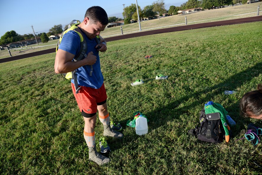 Staff Sgt. Shon Nguyen, 47th Medical Group aerospace medical technician, puts on his ruck gear on Laughlin Air Force Base, Texas, Oct. 17, 2015. Competitors weighing 150 pounds and over were required to carry a 20-pound rucksack; and those weighing under 150 pounds were required to carry a 10-pound rucksack. (U.S. Air Force photo by Airman 1st Class Ariel D. Partlow)(Released)