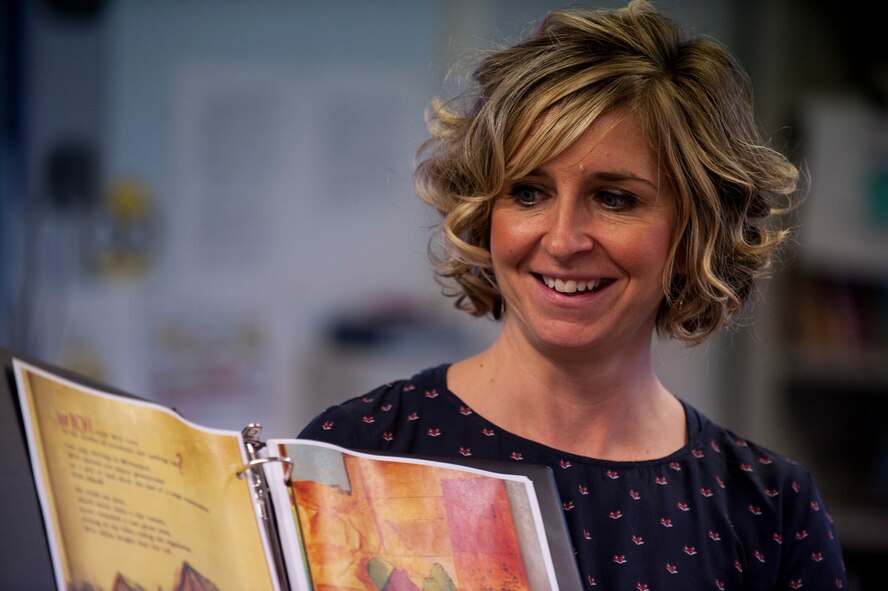 Jennifer Hensley, a Bitburg American Middle-High School teacher, smiles during a reading session for the Read Across the Globe event inside Spangdahlem Middle School Oct. 20, 2015, at Spangdahlem Air Base, Germany. Hensley read the book "Famer Will Allen and the Growing Table," during the session. (Air Force photo by Senior Airman Rusty Frank/Released)