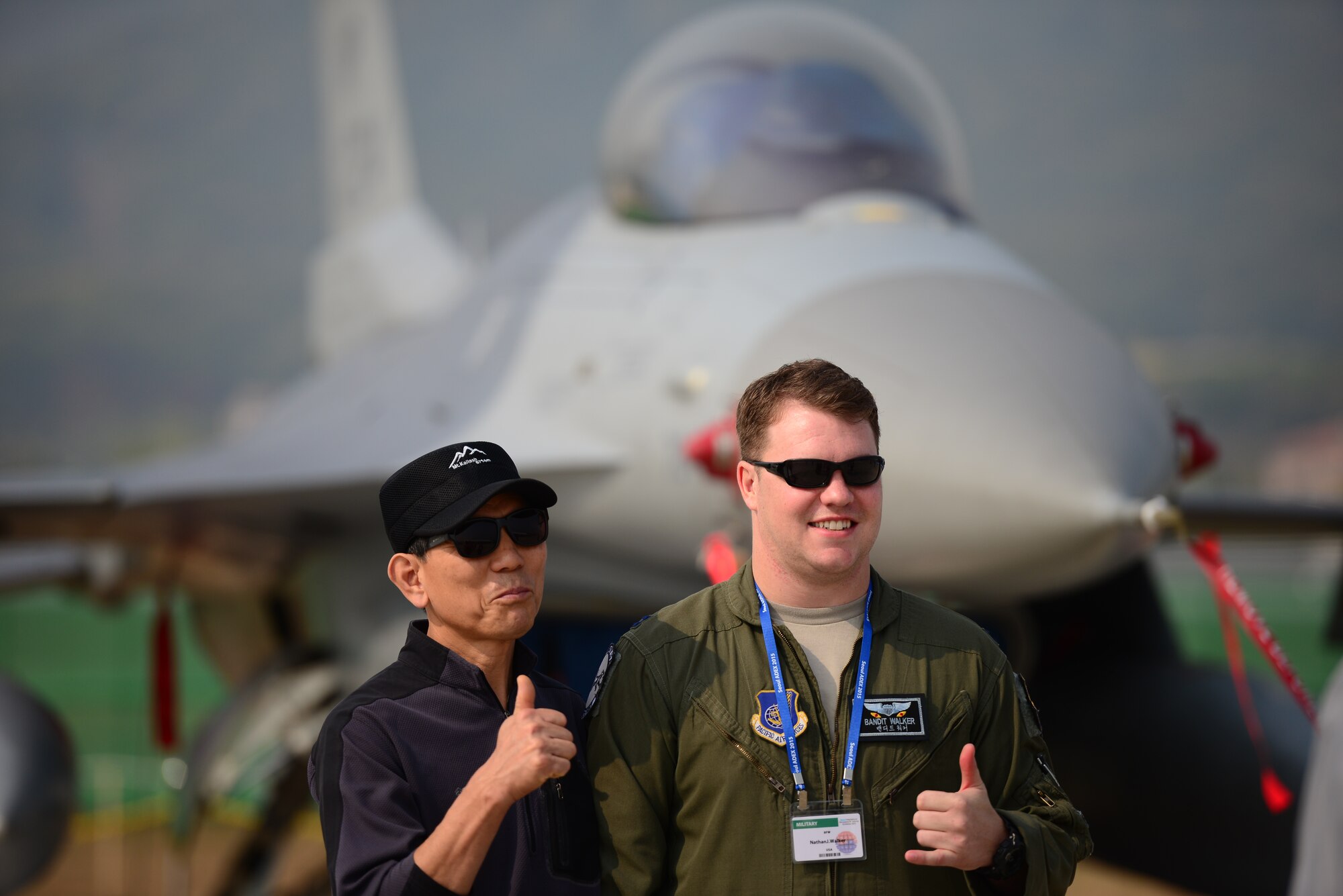 Capt. Nathan Walker, 35th Fighter Squadron, poses with a local Korean in front of an F-16 Fighting Falcon from Kunsan Air Base, at the Seoul International Aerospace and Defense Exhibition held just outside of Seoul, Republic of Korea, Oct. 19, 2015. The Seoul ADEX gives American service members a chance to showcase their outstanding aircraft and equipment to the Korean public. (U.S. Air Force photo/Staff Sgt. Amber Grimm)