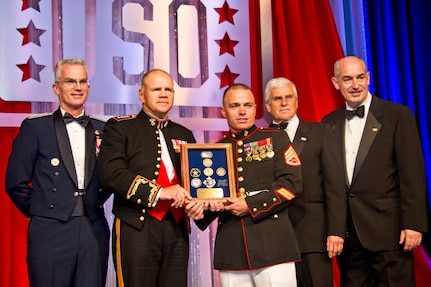 Air Force Gen. Paul Selva, left, vice chairman of the Joint Chiefs of Staff, Marine Corps Commandant Gen. Robert B. Neller, second left, and others, stop for a photo with Marine Corps Staff Sgt. Joseph P. Bednarik, center, during the 2015 USO Gala in Washington, D.C., Oct. 20, 2015. Bednarik was recognized as the USO Marine of the year during the event. U.S. Marine Corps photo by Sgt. Gabriela Garcia
