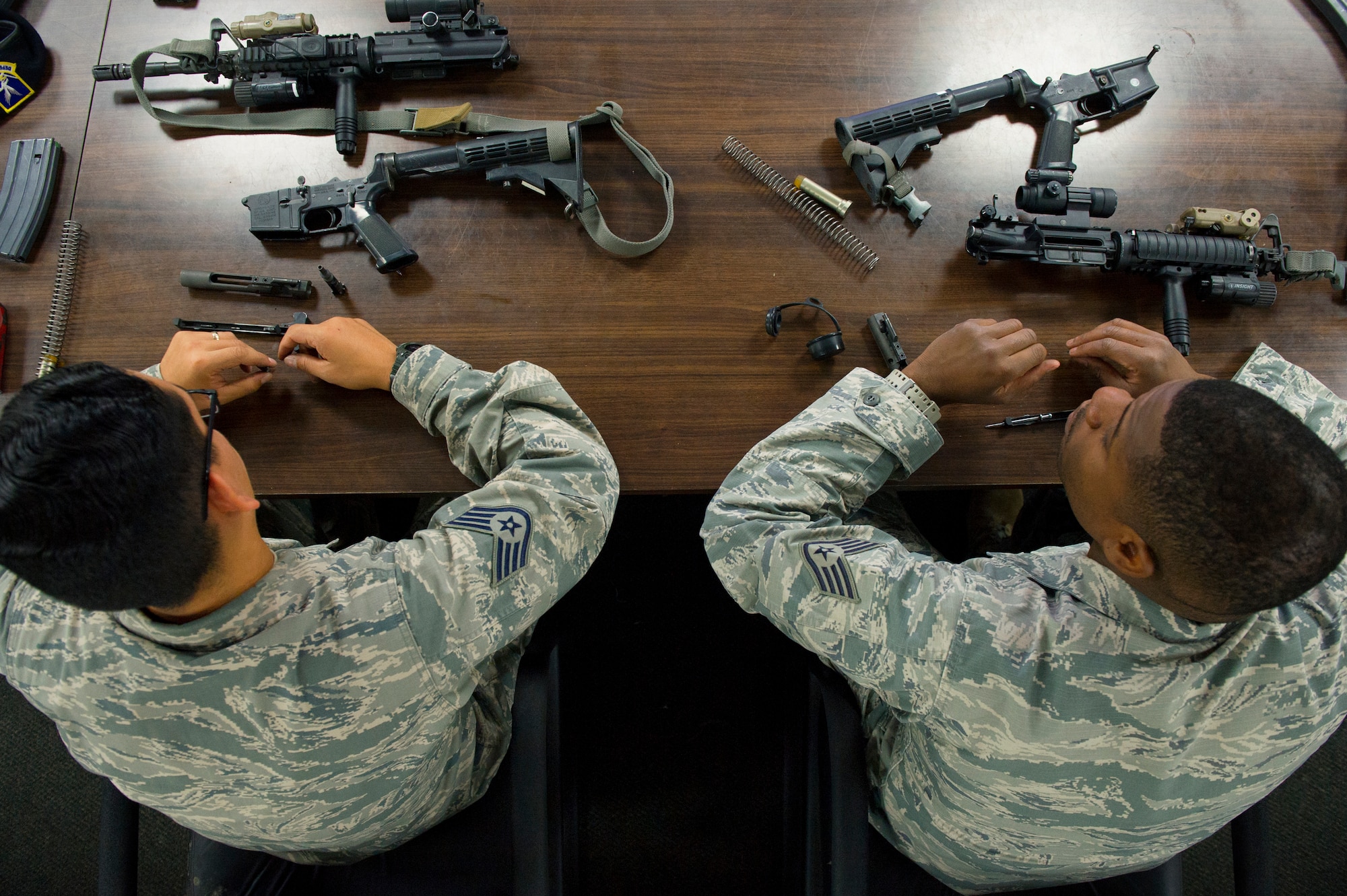 Security Forces Airmen practice disassembling M-4 Carbine assault rifles during a combat arms training class at Yokota Air Base, Japan, Oct. 8, 2015. Practicing proper weapon maintenance is one component of weapons training. (U.S. Air Force photo by Airman 1st Class Delano Scott/Released)