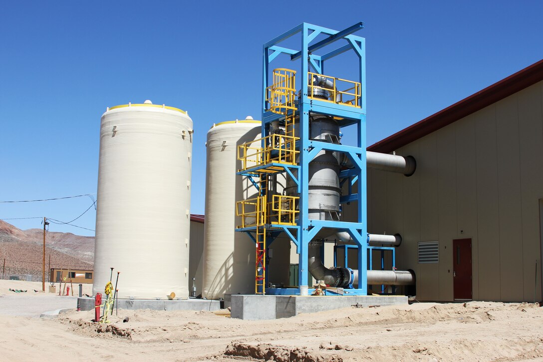 The phase separator of the mechanical evaporator located on the right of side of the photo is the third stage of the purification process.
The project is the design-build of a six million gallon per day water treatment plant. The new plant will use a three-stage, electro-dialysis reversal (EDR) water treatment plant that treats all contaminants found in Fort Irwin's ground water in accordance with federal and state requirements.
The plant will include: an electro-dialysis reversal (EDR) primary treatment, lime softening clarifiers, lime solids thickeners, lime sludge lagoons, reverse osmosis (RO) filters, brine treatment facility, concentrate equalization basins and a mechanical evaporator tower and feed tank, and three evaporation ponds to achieve the post’s 99 percent water recovery rate.
The project also includes water system improvement and supporting utilities and infrastructure upgrades

