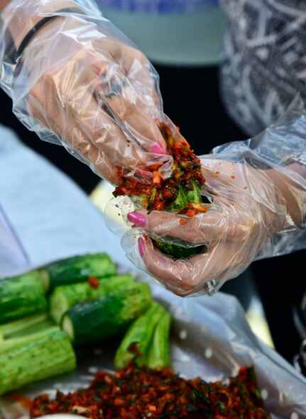 A woman makes kimchi at the 12th annual Korean American Friendship Festival in the Songtan Entertainment District, Republic of Korea, Oct. 17, 2015. Kimchi is a traditional fermented Korean side dish made of vegetables with a variety of seasonings. In traditional preparation, kimchi is stored underground in jars to keep cool during the summer months and unfrozen during the winter months. There are hundreds of varieties of kimchi made from napa cabbage, radish, scallion or cucumber as a main ingredient. (U.S. Air Force photo/Senior Airman Kristin High)