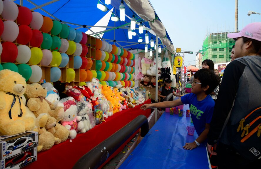 A child throws a dart to win a prize during the 12th annual Korean American Friendship Festival in the Songtan Entertainment District, Republic of Korea, Oct. 17, 2015. The streets of Songtan were filled with thousands of both American and Korean patrons for the two-day event. (U.S. Air Force photo/Senior Airman Kristin High)