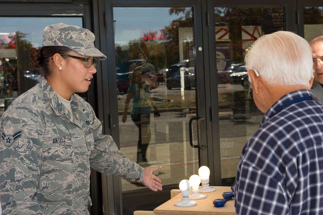 Airman 1st Class LaLynn Antell, 11th Civil Engineer Squadron engineering apprentice, explains information about conserving energy to a community member at the Energy Action Day booth, Oct. 21, 2015, at the Base Exchange on Joint Base Andrews, Md. The booth, as part of Energy Awareness Month, informed community members of cost saving tips on conserving energy and included a demonstration and resources on how to do so. (U.S. Air Force photo by Senior Airman Dylan Nuckolls/Released)