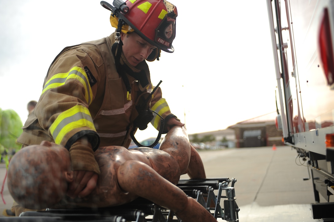 Staff Sgt. Matthew Wright, 28th Civil Engineer Squadron firefighter crew chief, places a rescue dummy onto a mass decontamination trailer conveyor belt during a hazardous material training exercise at Ellsworth Air Force Base, S.D., Oct. 9, 2015. The mass decontamination trailer and conveyor belt are used for situations where large numbers of victims are present and need to receive chemical sterilization after being contaminated. (U.S. Air Force photo by Airman Sadie Colbert/Released) 