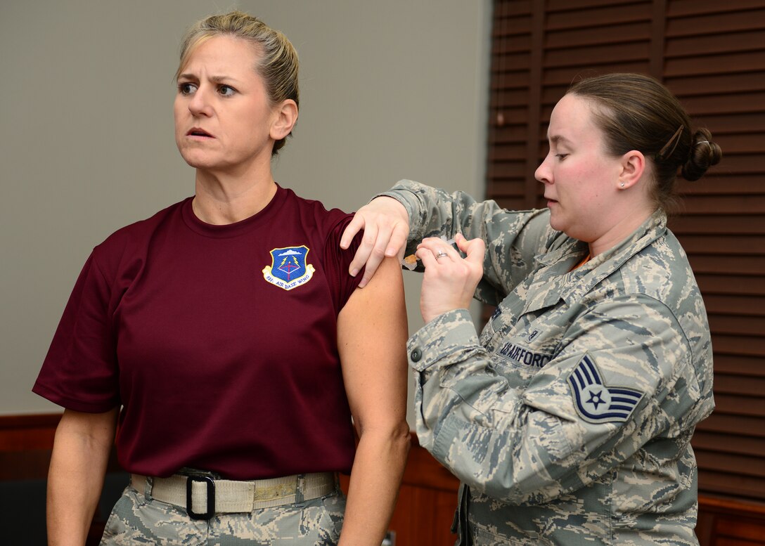 U.S. Air Force Col. Caroline Miller, 633rd Air Base Wing commander, receives her annual flu shot from Staff Sgt. Julianne Wenger, 633rd Medical Operations Squadron, at Langley Air Force Base, Va., Oct. 16, 2015. Flu vaccinations are set to be available for active duty Service members, government employees and first responders Oct. 21-22 from 7 a.m., until 5 p.m., at the Community Commons. (U.S. Air Force photo by Staff Sgt. Ciara Gosier/Released) 