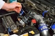 Senior Airman Thomas Kirts, 374th Civil Engineer Squadron driver operator, checks the oil levels of his car in preparation for a race at Fuji Speedway, Japan, Oct. 17, 2015. Kirts continually upgrades his vehicles with new parts and conducts his own maintenance to compete in races. (U.S. Air Force photo by Airman 1st Class Elizabeth Baker/Released)
