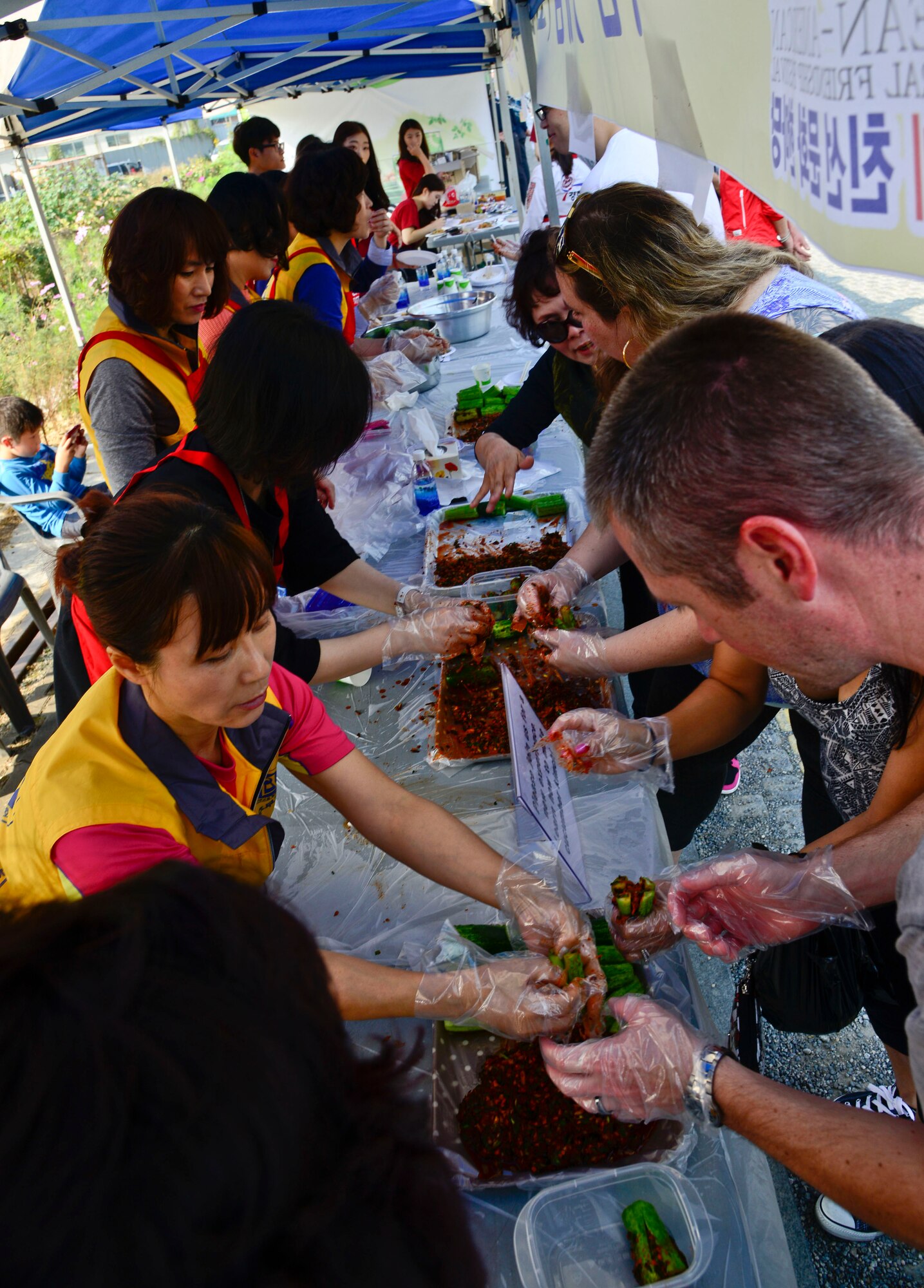 Members of Team Osan learn how to make kimchi during the 12th annual Korean American Friendship Festival in the Songtan Entertainment District, Republic of Korea, Oct. 17, 2015. The festival is a two-day event held to celebrate the partnership of the U.S. and ROK, along with helping both cultures learn about each other. (U.S. Air Force photo/Senior Airman Kristin High)