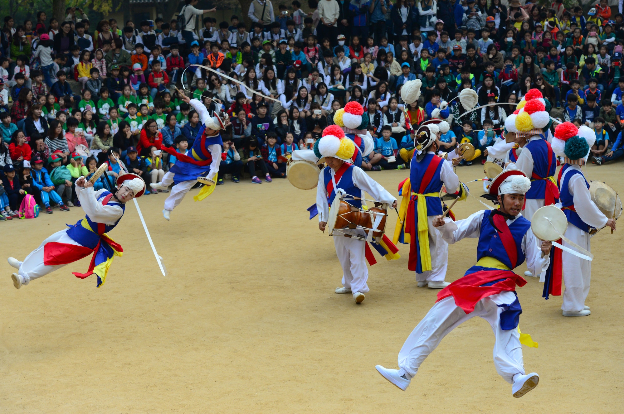 Entertainers perform the “Farmers Dance” for a crowd of school children at the Korean Folk Village in Yongin, Republic of Korea, Oct. 16, 2015. The village is a place where the rich history of Korea comes to life in an amazing display of color and pageantry. 
(U.S. Air Force photo/Staff Sgt. Amber Grimm)