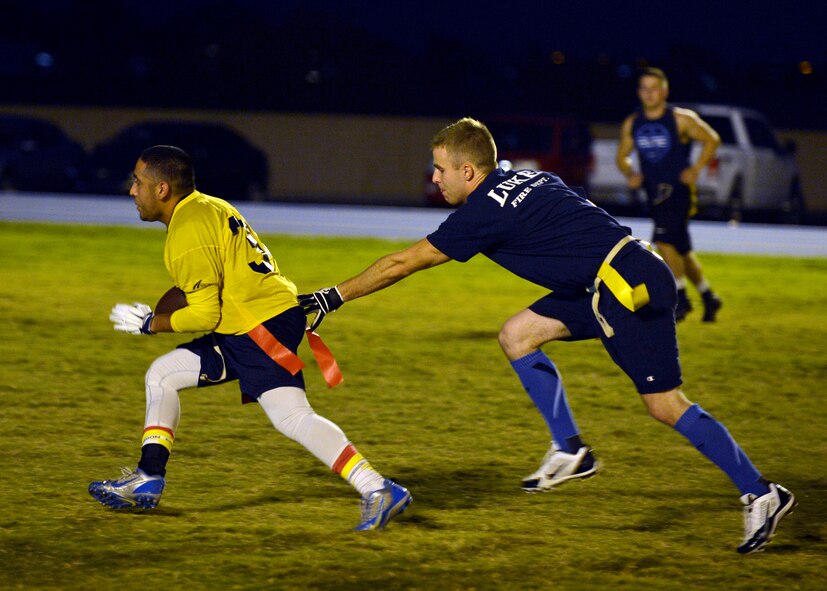 Rafael Lopez, 56th Equipment Maintenance Squadron, tires to avoid the defender during an intramural flag football matchup against 56th Civil Engineer Squadron at Luke Air Force Base, Ariz., Oct. 19, 2015. Lopez completed the play for a first down. (U.S. Air Force photo by Senior Airman Devante Williams)