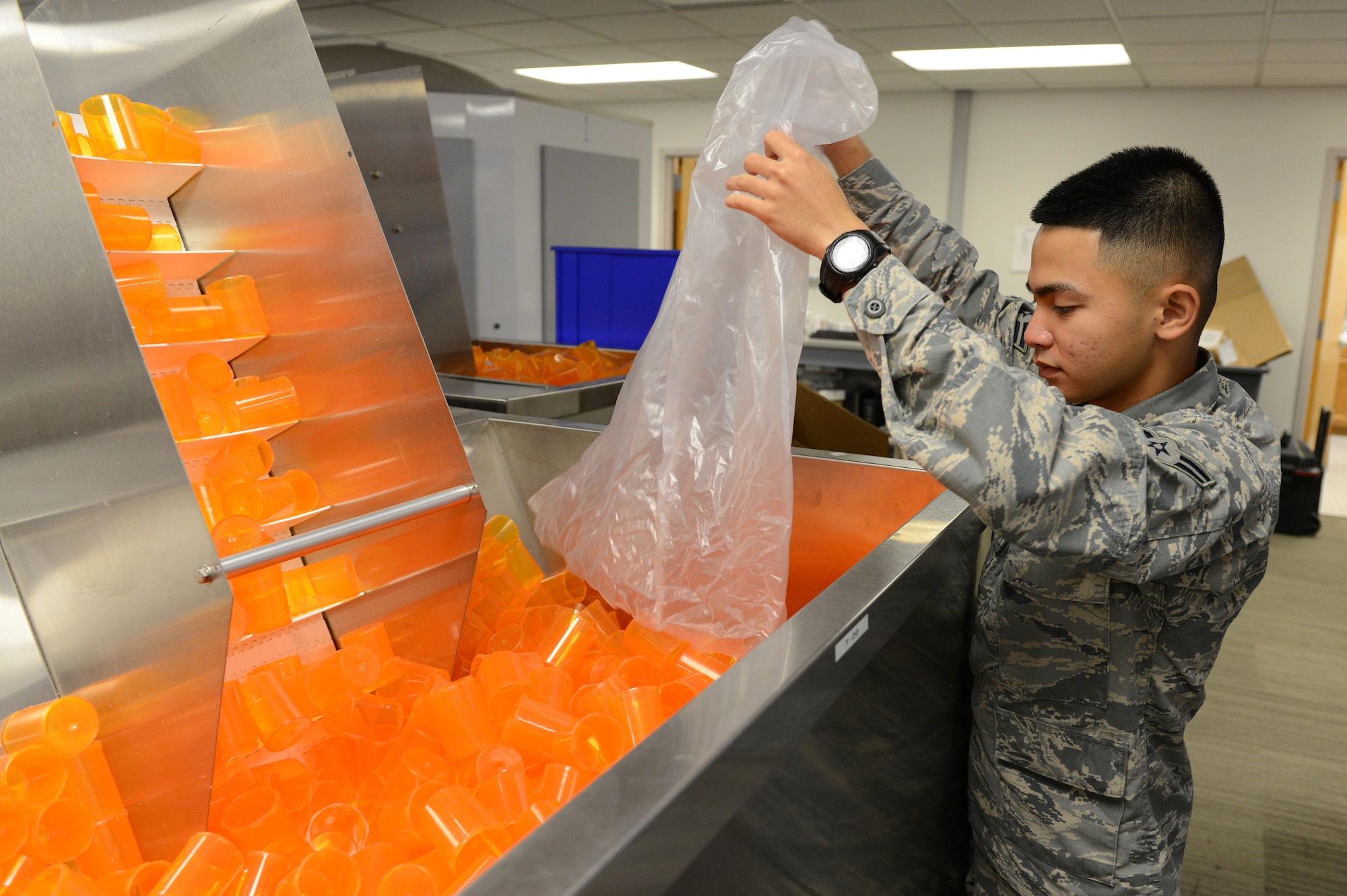Airman 1st Class Michael Pacla, 56th Medical Support Squadron pharmacy technician, refills the prescription bottle dispenser at Luke Air Force Base, Arizona, Oct. 19, 2015. The bottles get loaded through the conveyor belt and get labelled at user request autonomously. (U.S. Air Force photo by Senior Airman James Hensley)